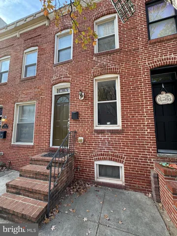 a front view of a brick house with many windows