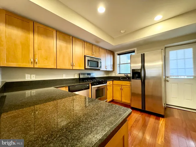 a kitchen with granite countertop a refrigerator and a sink