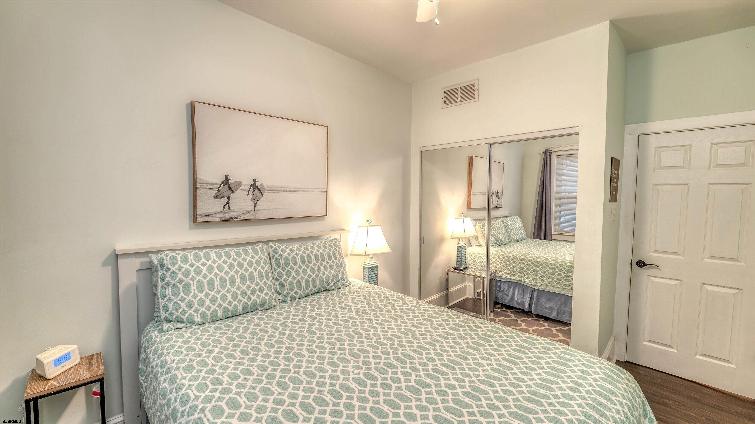 1102 Wesley Avenue, Unit 1 Ocean City, NJ 08226 - Photo 11 of 19 a bedroom with a bed and a painting on the wall