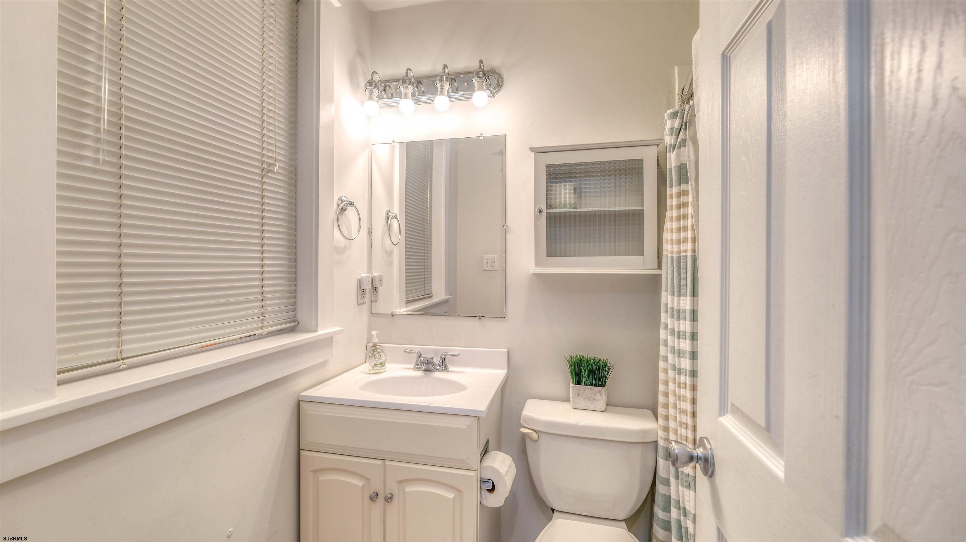 1102 Wesley Avenue, Unit 1 Ocean City, NJ 08226 - Photo 12 of 19 a bathroom with a toilet sink and mirror