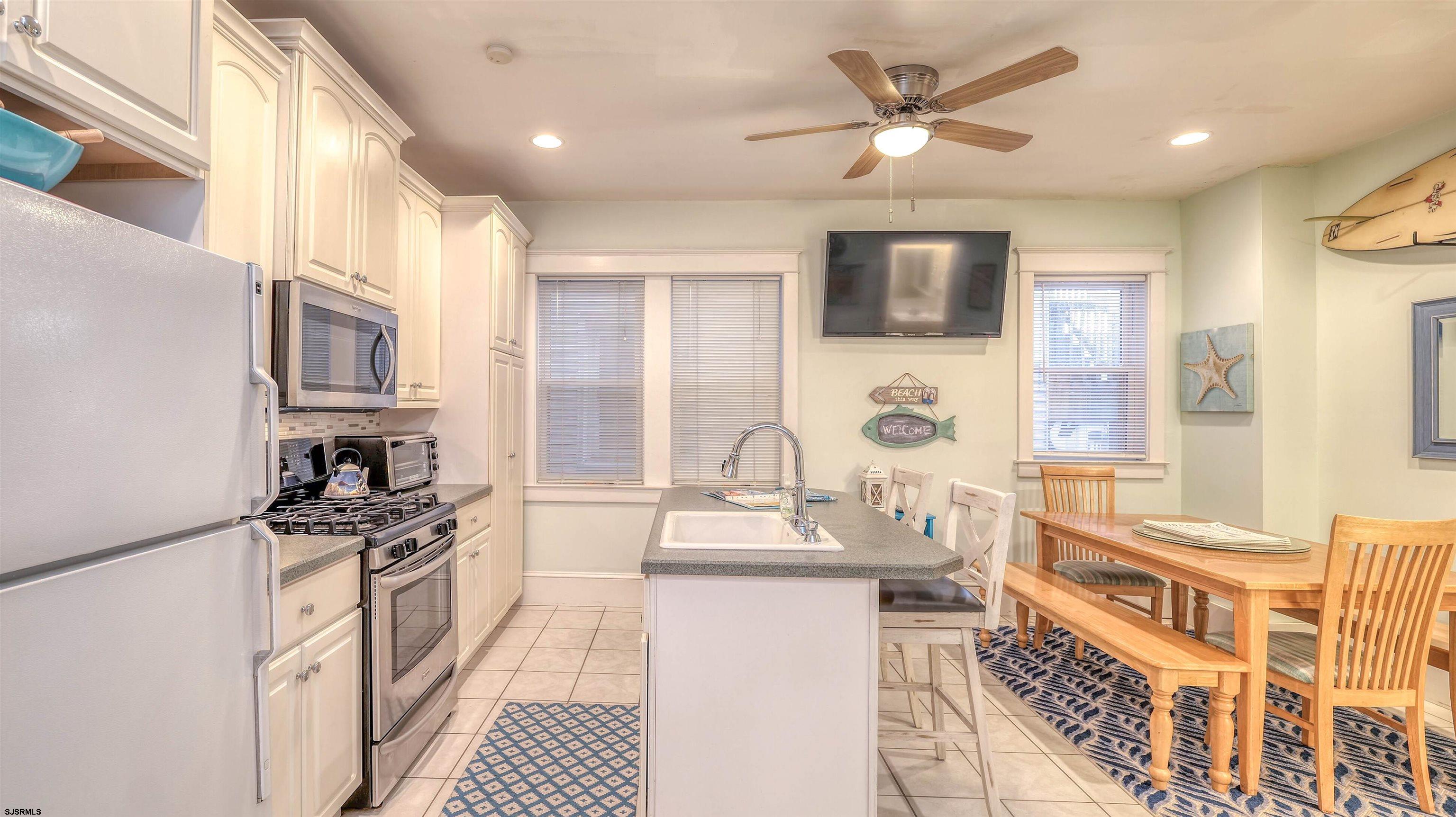 1102 Wesley Avenue, Unit 1 Ocean City, NJ 08226 - Photo 13 of 19 a kitchen with stainless steel appliances granite countertop a stove a sink and a refrigerator