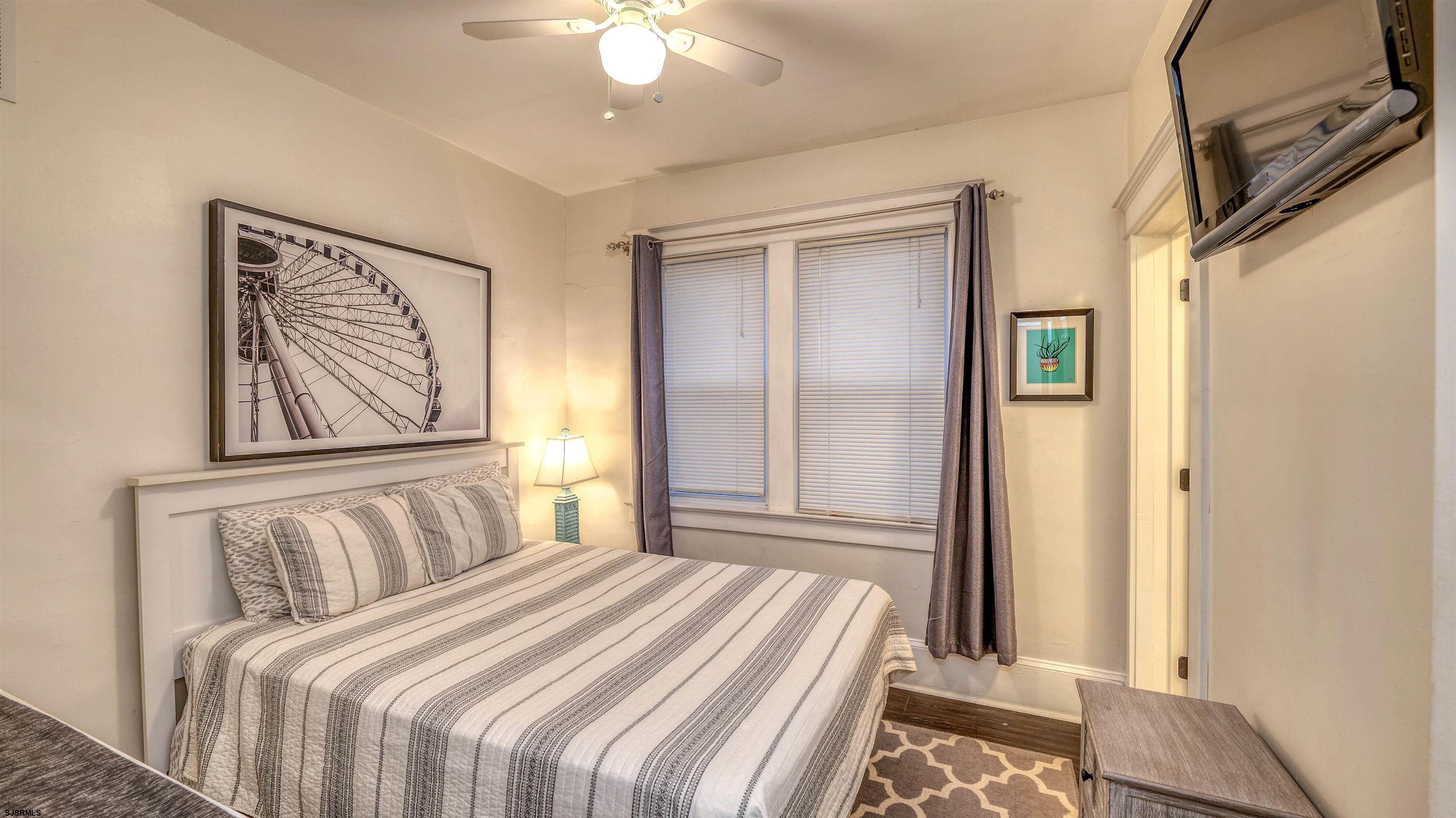 1102 Wesley Avenue, Unit 1 Ocean City, NJ 08226 - Photo 7 of 19 a bedroom with a bed and a chandelier