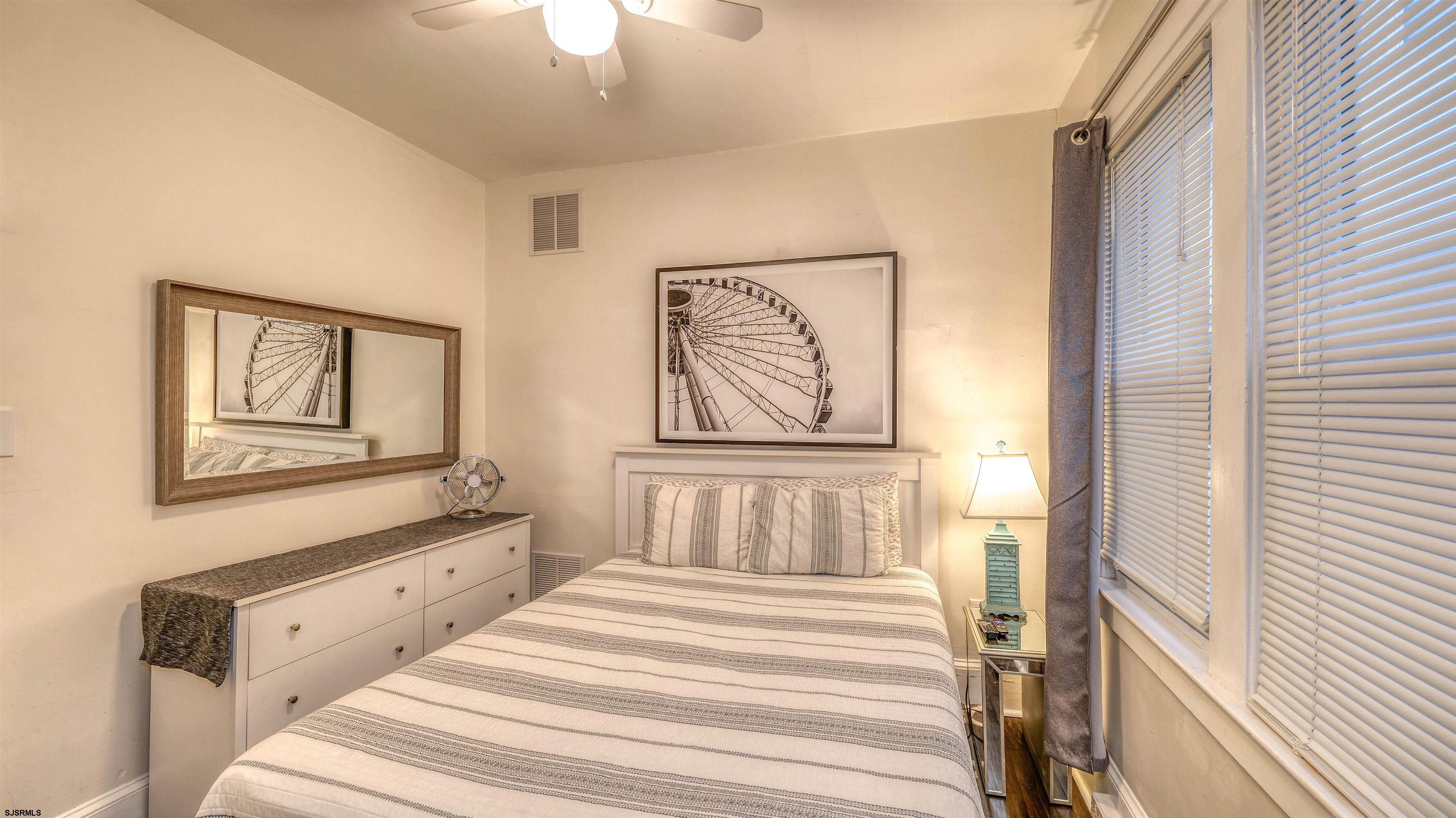 1102 Wesley Avenue, Unit 1 Ocean City, NJ 08226 - Photo 8 of 19 a bedroom with a bed and a painting on the wall