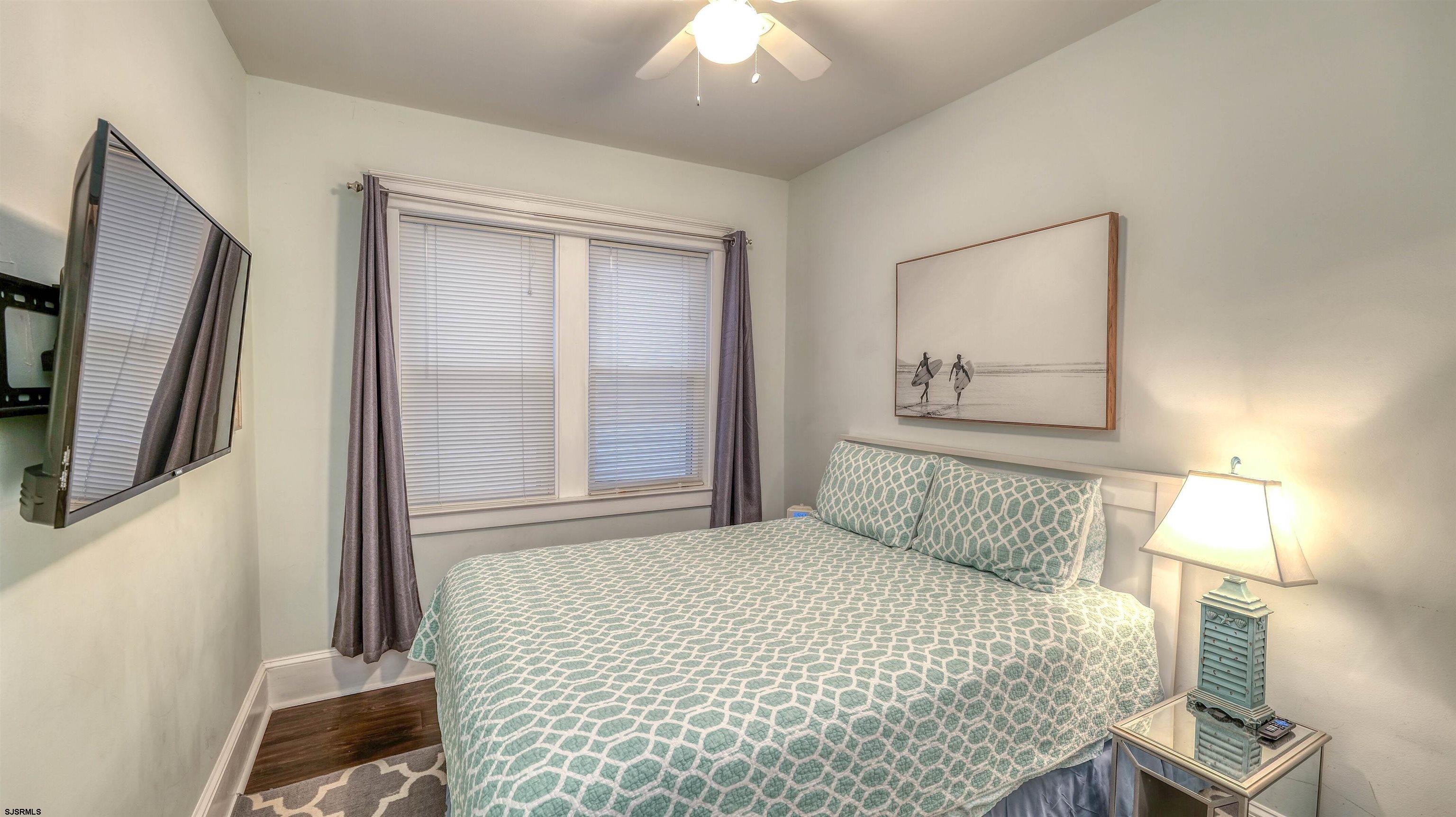 1102 Wesley Avenue, Unit 1 Ocean City, NJ 08226 - Photo 10 of 19 a bedroom with a bed and a large mirror