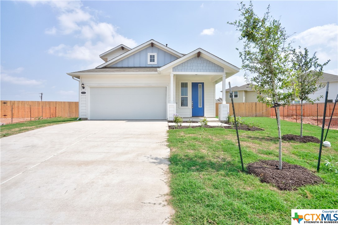 a front view of a house with plants and garden