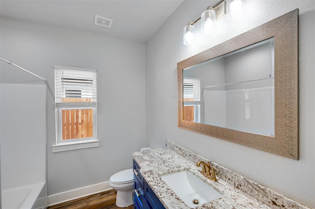 2830 Juniper Lane Tyler, TX 75701 - Photo 26 of 34 a bathroom with a granite countertop sink toilet and mirror