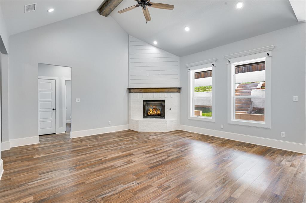 2830 Juniper Lane Tyler, TX 75701 - Photo 8 of 34 an empty room with wooden floor chandelier fan and windows