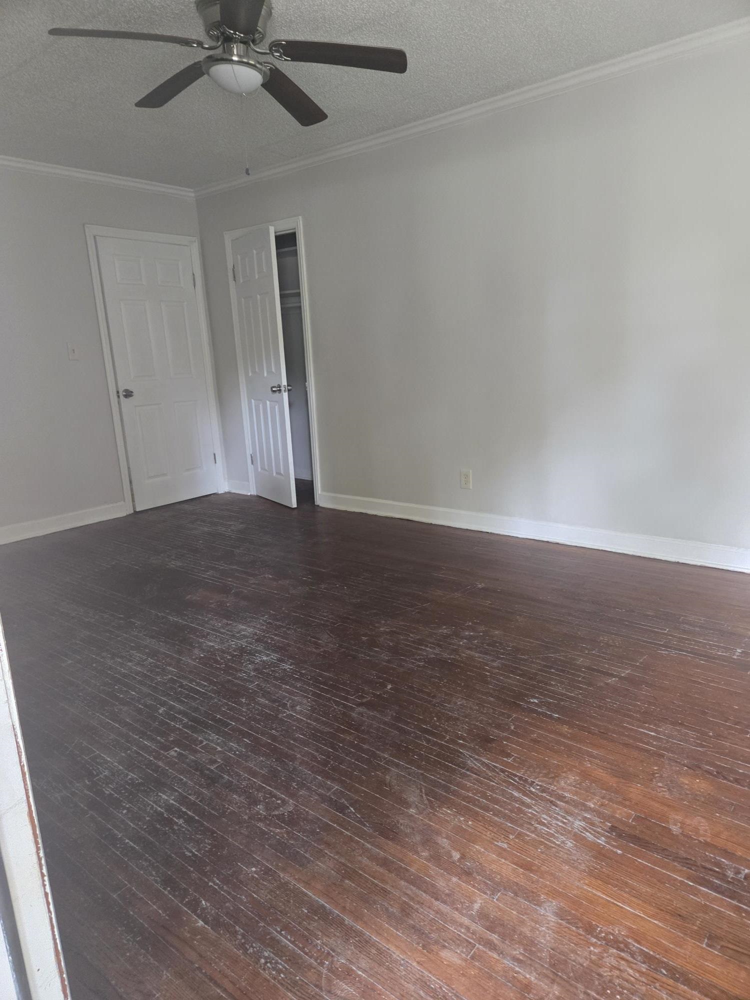 Unfurnished room with hardwood / wood-style floors, a ceiling fan, and ornamental molding