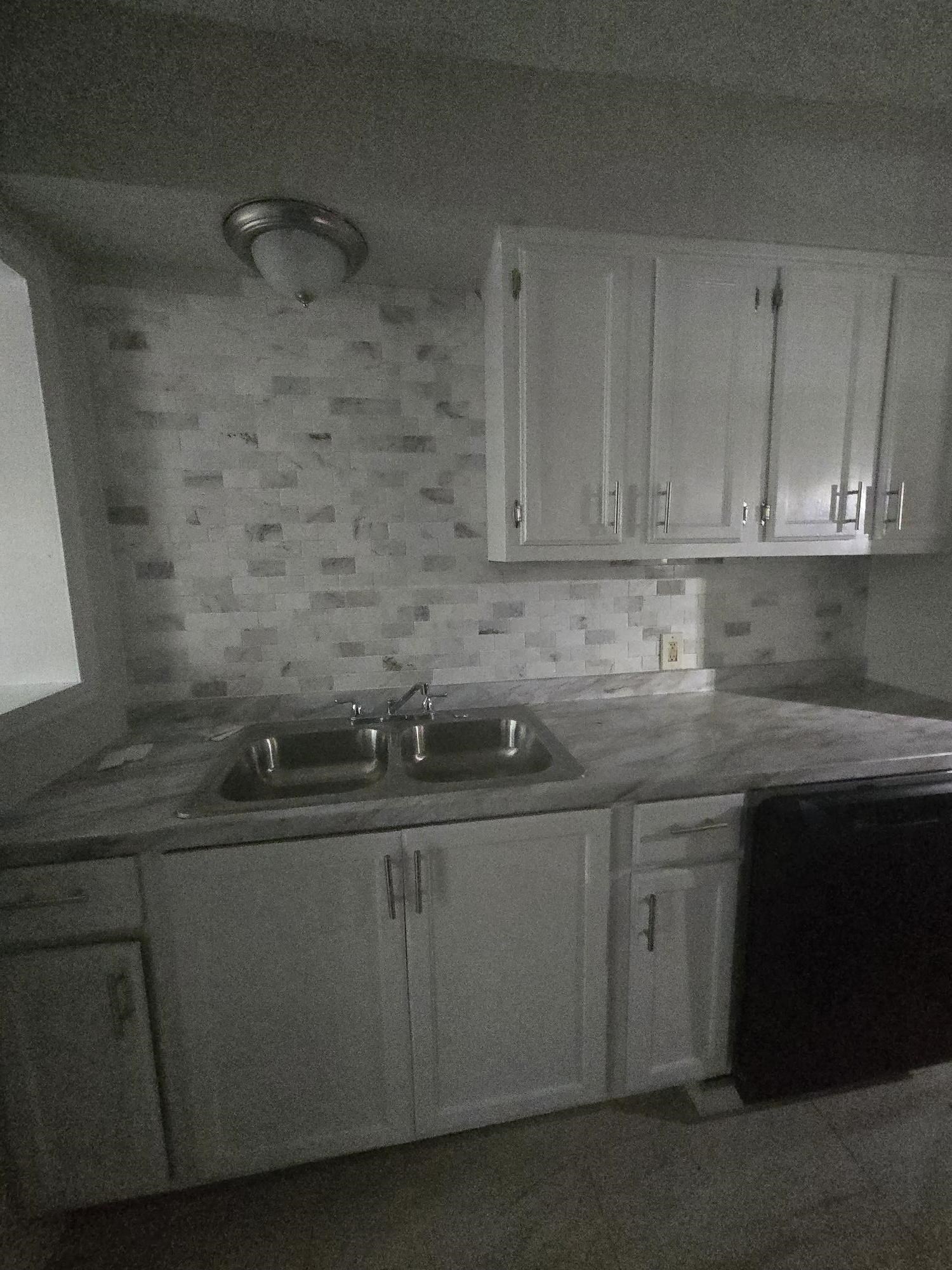 Kitchen featuring white cabinetry, light countertops, and decorative backsplash