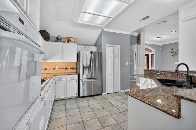 a kitchen with refrigerator and cabinets
