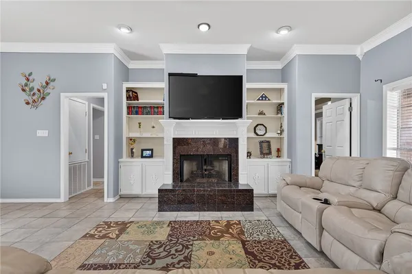 a living room with furniture a flat screen tv and a fireplace
