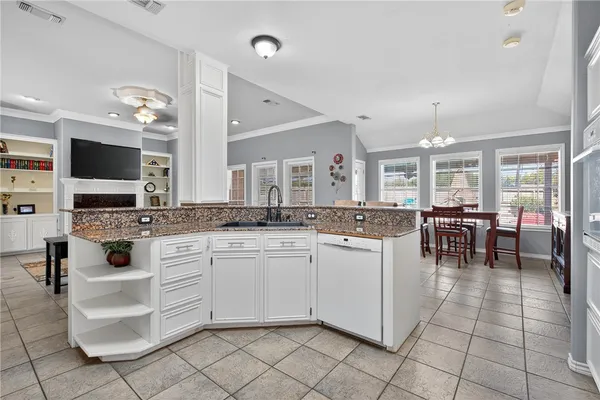 a kitchen with cabinets and chairs