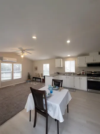 a kitchen with kitchen island a dining table chairs and a refrigerator