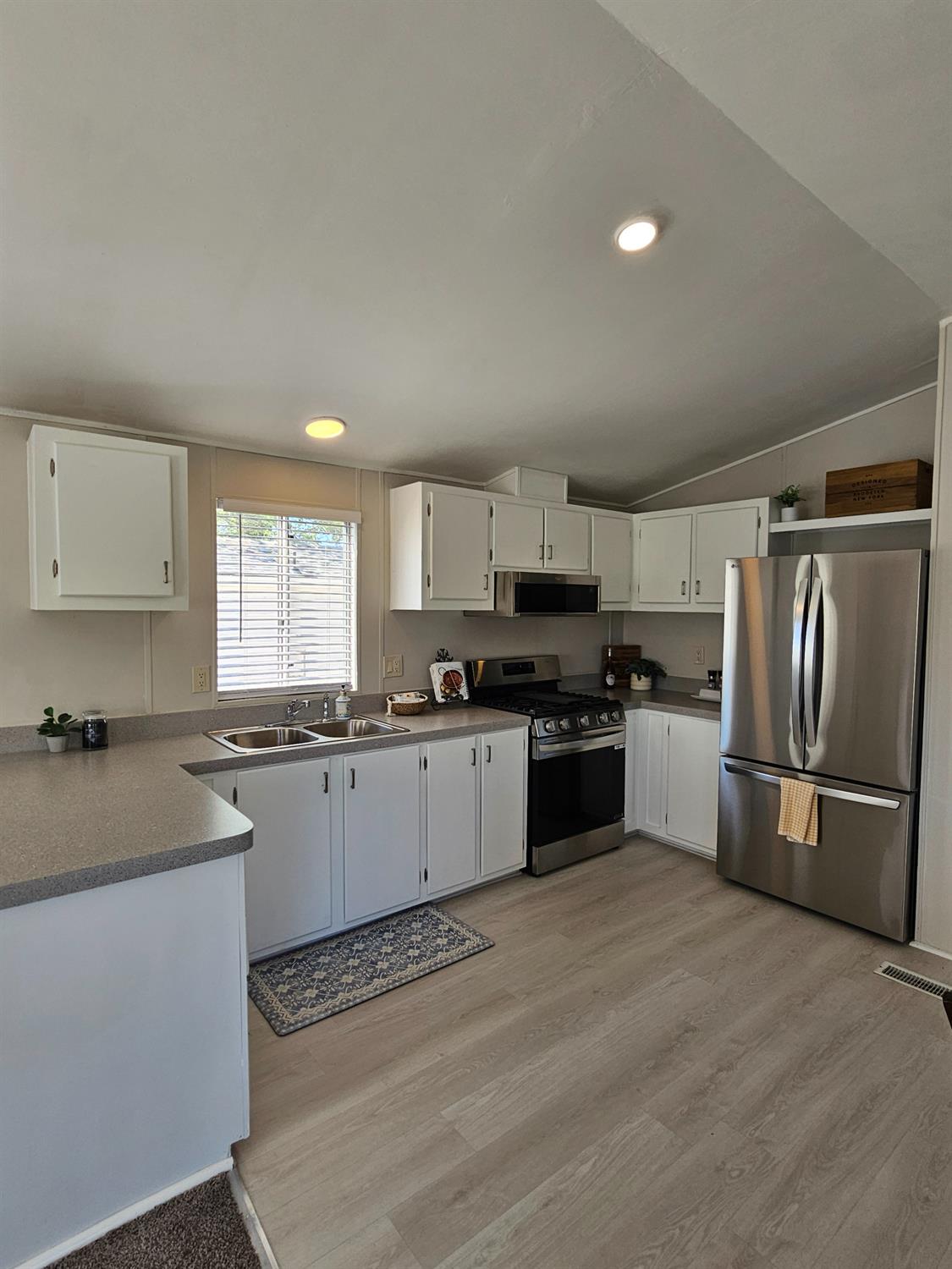 3440 Fulton Avenue, Unit 33 Sacramento, CA 95821 - Photo 17 of 19 a kitchen with granite countertop white cabinets and stainless steel appliances