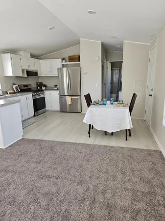a living room with furniture and kitchen view