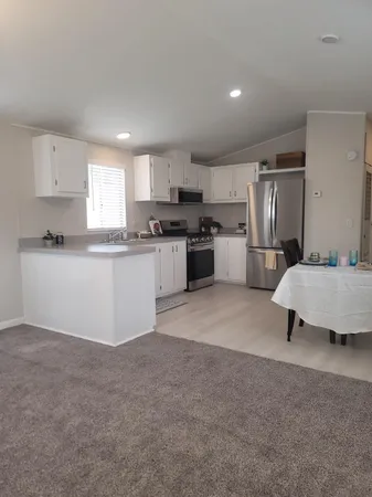 a kitchen with stainless steel appliances granite countertop a refrigerator sink and stove