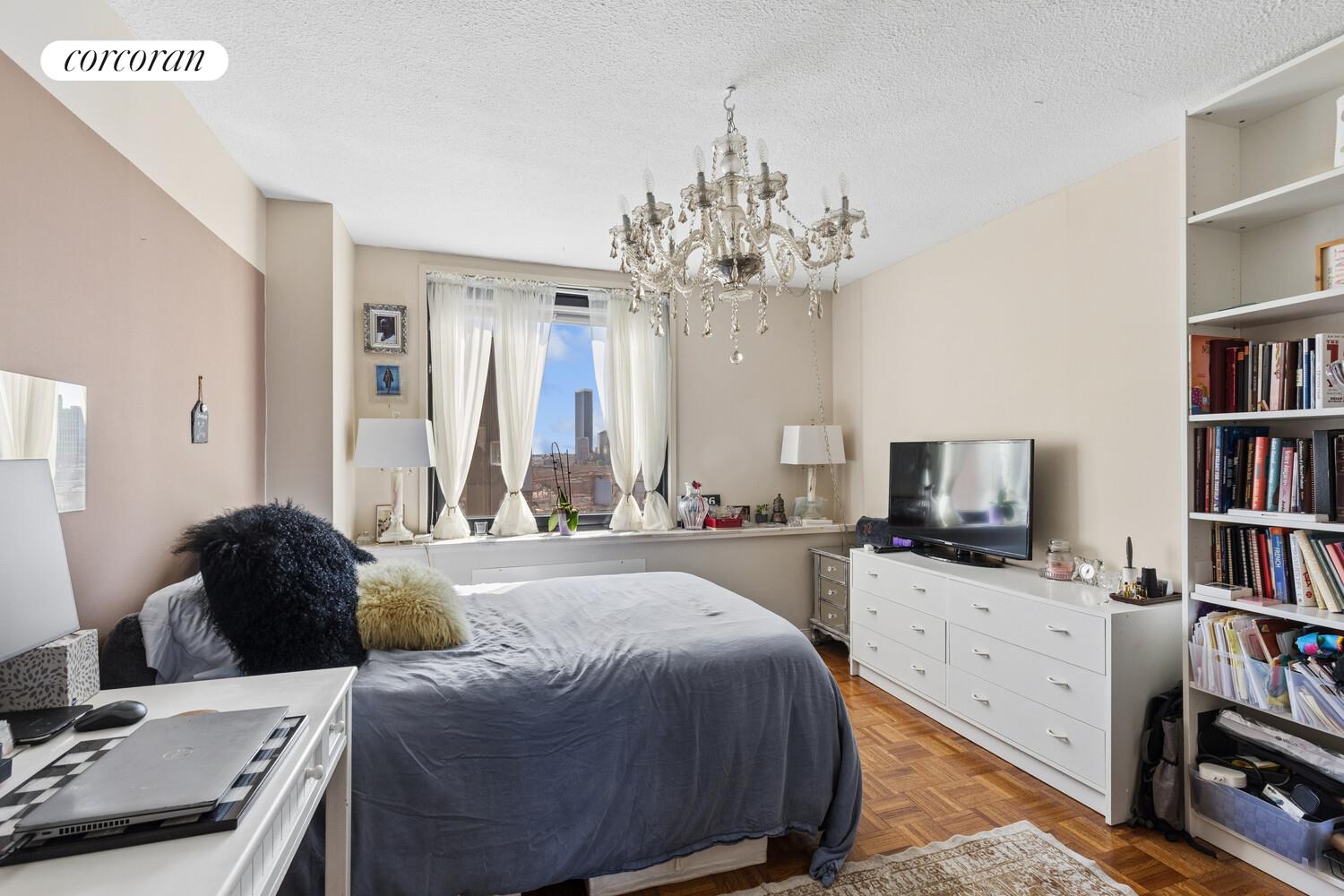 531 Main Street, Unit 1502 Manhattan, NY 10044 - Photo 9 of 11 a bed room with a bed and a television