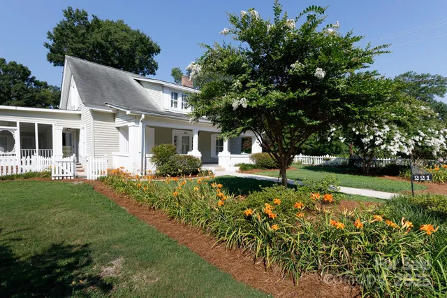 a front view of a house with a yard and shrubs