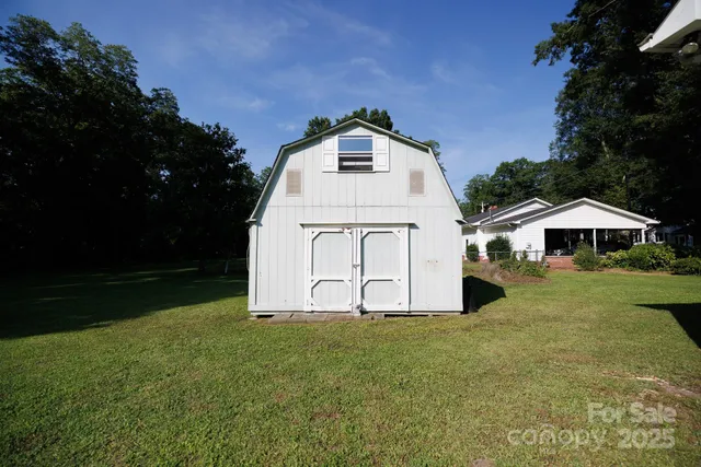 an aerial view of residential house with outdoor space and trees all around