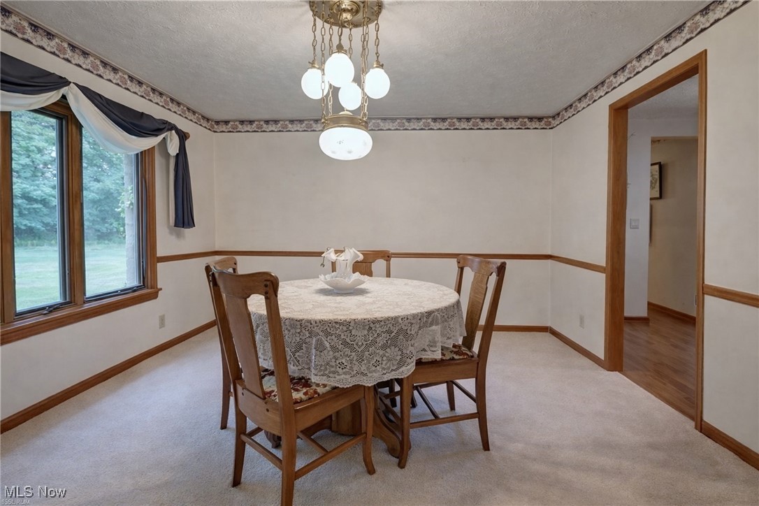 14965 Seacrist Road Salem, OH 44460 - Photo 11 of 43 Dining room featuring a textured ceiling, light colored carpet, and a chandelier
