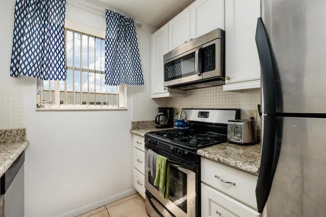 a kitchen with stainless steel appliances granite countertop a stove microwave and sink