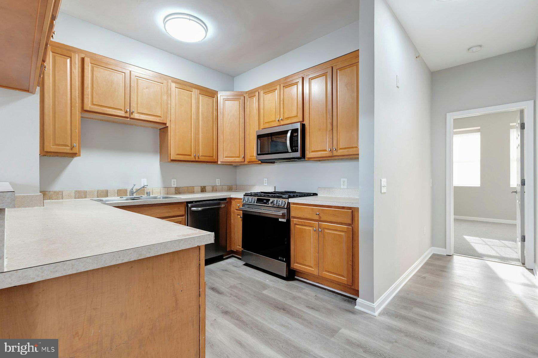 1838 Cedar Cove Way, Unit 201 Woodbridge, VA 22191 - Photo 12 of 38 a kitchen with stainless steel appliances granite countertop a stove a sink and a microwave