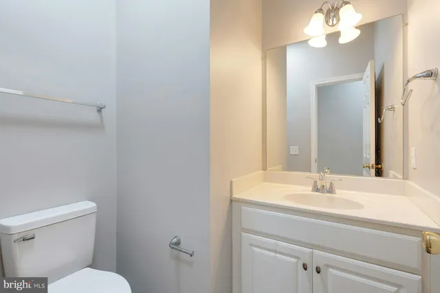 a bathroom with a sink vanity mirror and toilet