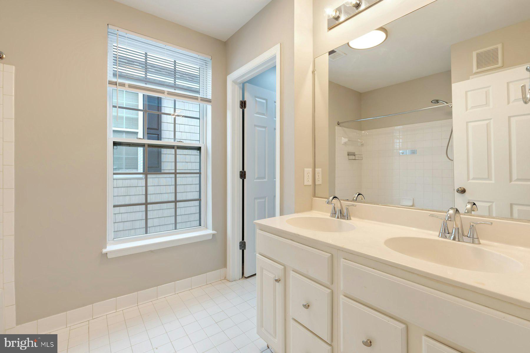 1838 Cedar Cove Way, Unit 201 Woodbridge, VA 22191 - Photo 28 of 38 a bathroom with a sink double vanity and a tub