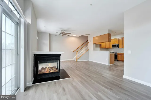 a hallway with wooden floor a fireplace and entryway