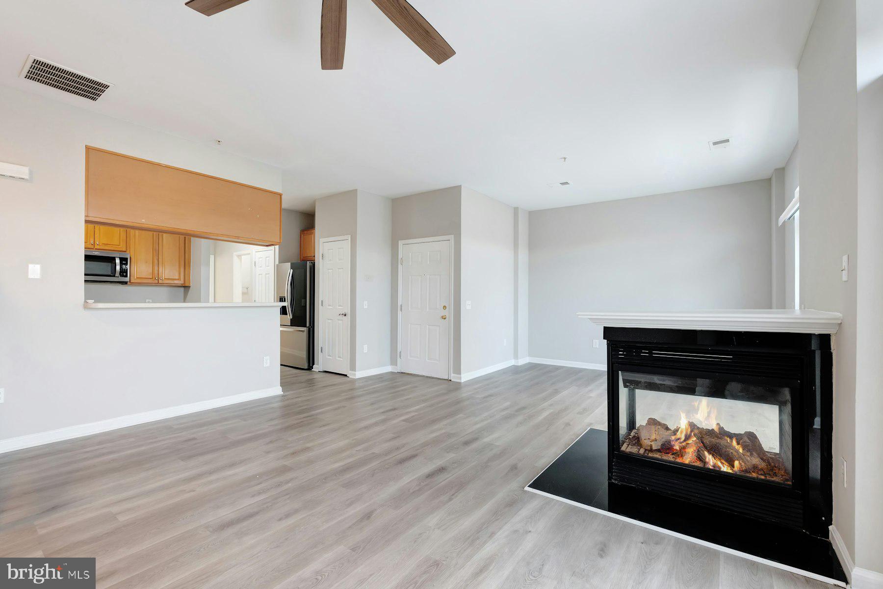 1838 Cedar Cove Way, Unit 201 Woodbridge, VA 22191 - Photo 8 of 38 a view of an empty room with wooden floor and a fireplace