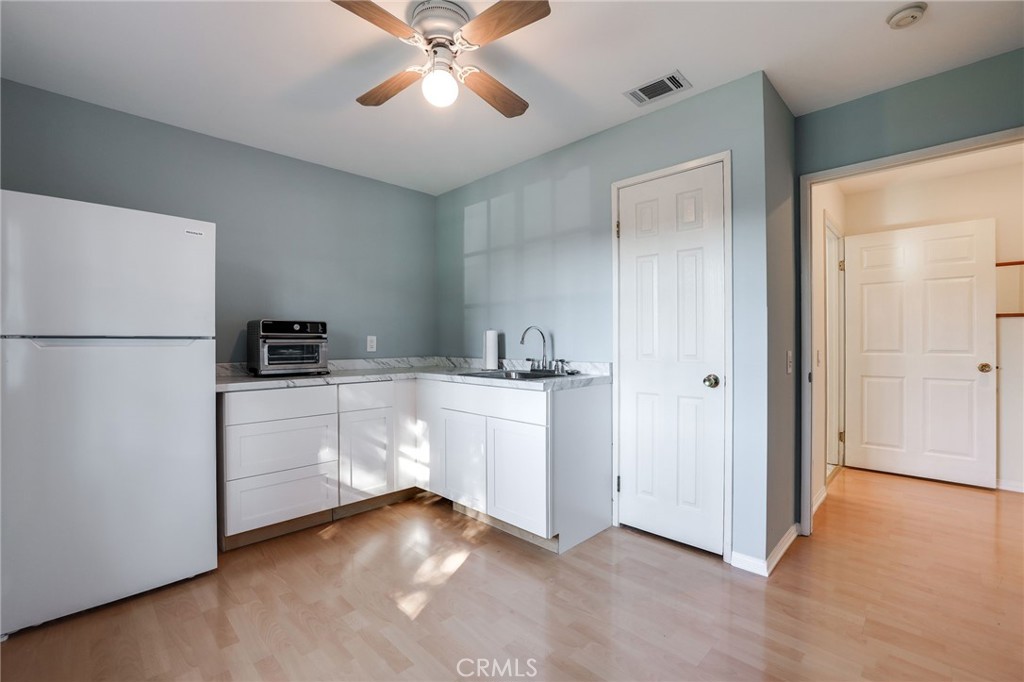 10485 Parakeet Circle Fountain Valley, CA 92708 - Photo 9 of 11 a kitchen with a refrigerator and white cabinets