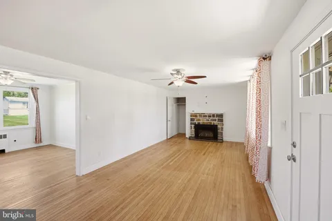 a view of an empty room with a fireplace and a window