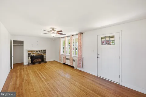a view of empty room with fireplace and wooden floor