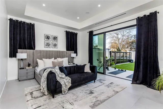 a bedroom with a bed a flat screen tv and a couch