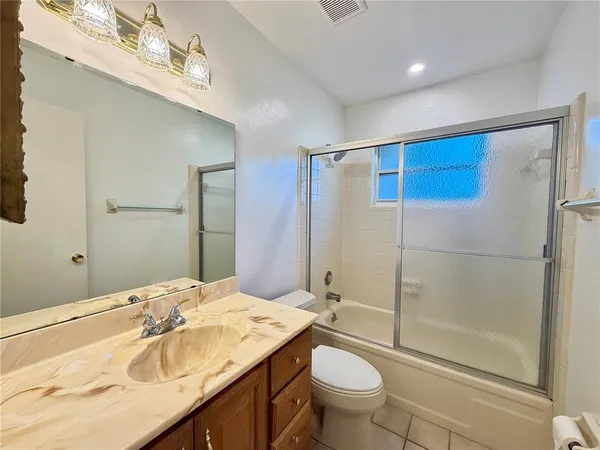 a bathroom with a granite countertop sink toilet mirror and shower