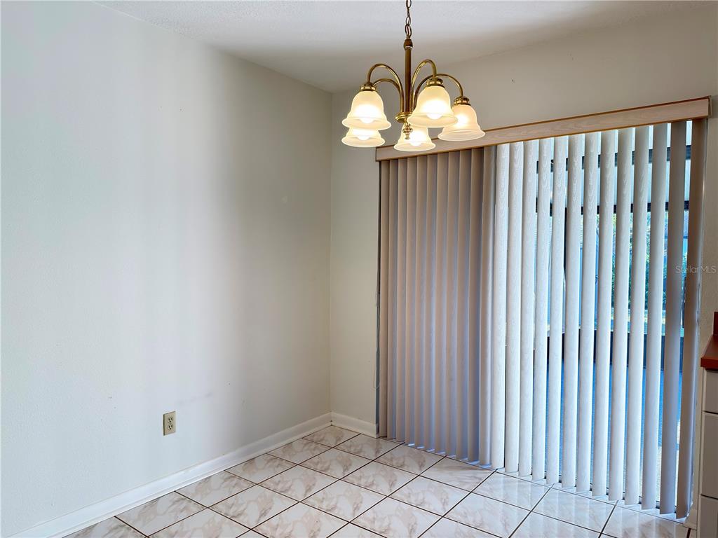 411 Parson Brown Way Longwood, FL 32750 - Photo 14 of 48 a view of an empty room with wooden floor and a chandelier