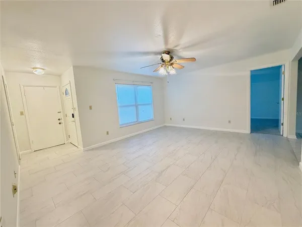 a view of empty room with ceiling fan