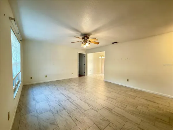 a view of a livingroom with a ceiling fan and window