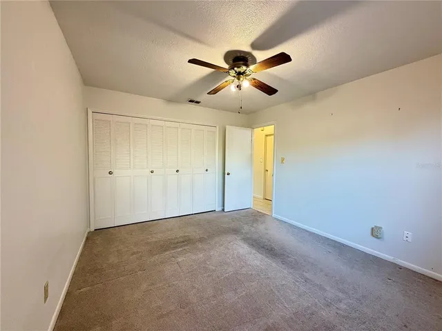 an empty room with fan and windows