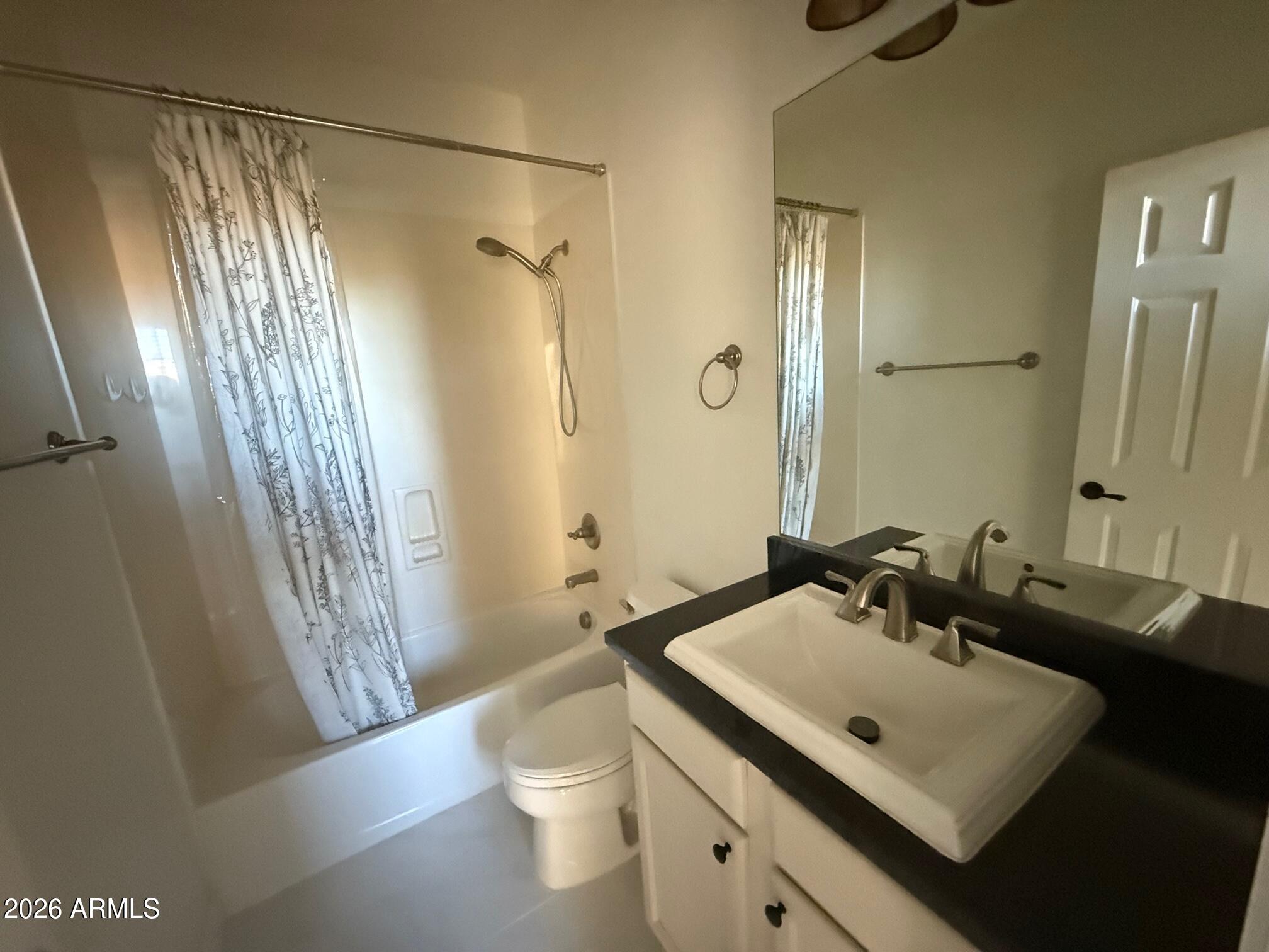 3935 East Rough Rider Road, Unit 1057 Phoenix, AZ 85050 - Photo 16 of 21 a bathroom with a sink a toilet a mirror and shower