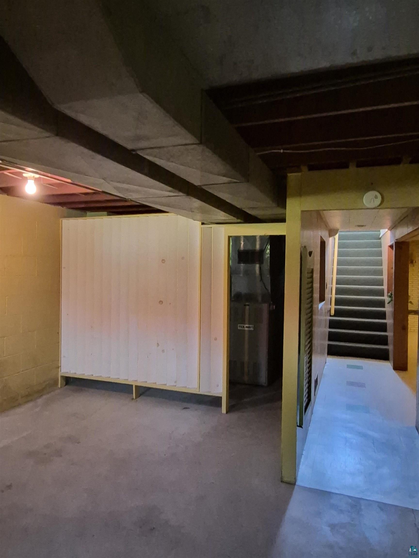 2109 West 22nd Street Duluth, MN 55811 - Photo 23 of 29 Basement utility area featuring concrete flooring, exposed overhead ductwork, and painted concrete block walls.