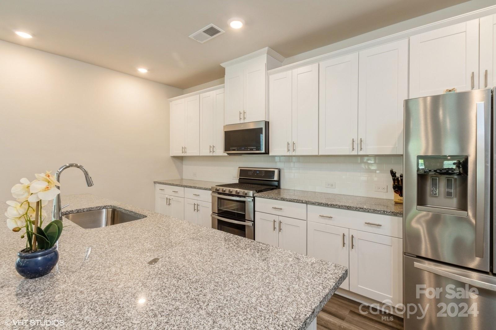 11955 Old Statesville Road Huntersville, NC 28078 - Photo 15 of 39 a kitchen with stainless steel appliances granite countertop a stove a sink dishwasher and a refrigerator