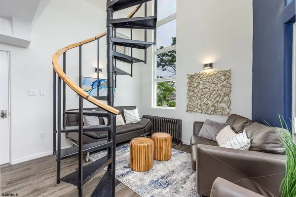 a kitchen with a sink dishwasher a dining table and chairs with wooden floor
