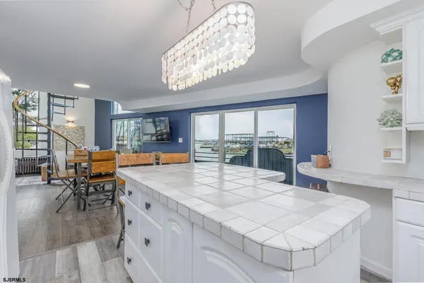 a living room with furniture a flat screen tv and kitchen view