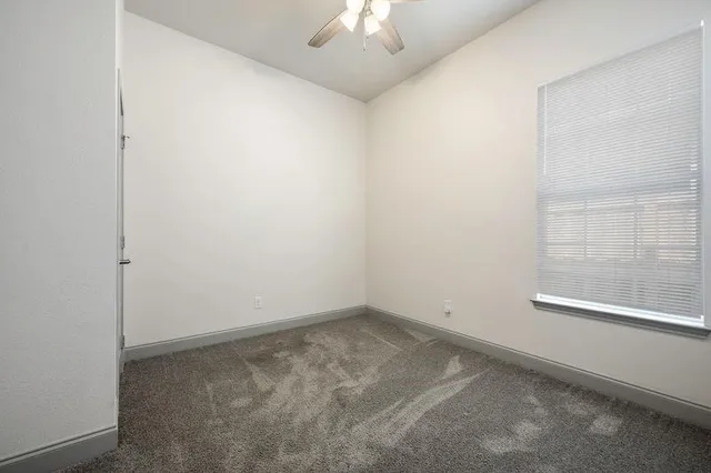 an empty room with a chandelier fan