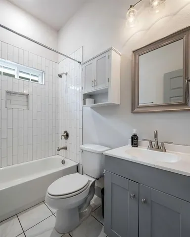 a bathroom with a toilet a sink a mirror a bathtub and vanity