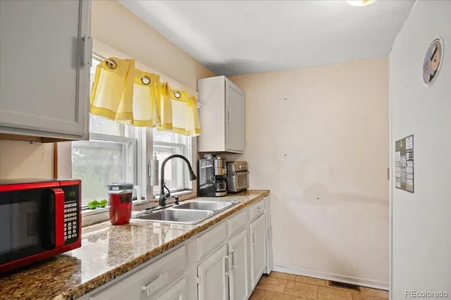 a kitchen with a sink cabinets and a window