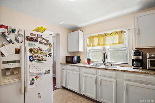 a kitchen with stainless steel appliances white cabinets and a window