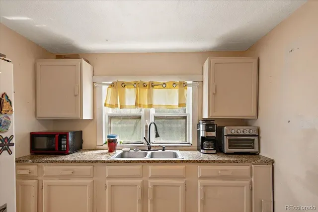 a kitchen with granite countertop a sink and a stove