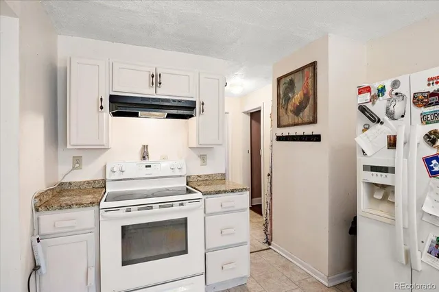 a kitchen with stainless steel appliances white cabinets and white appliances